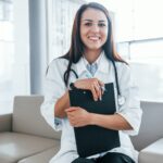 With notepad. Young nurse indoors in modern clinic. Conception of healthcare